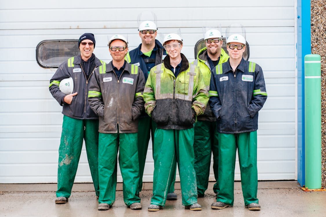 A plant team in work clothes and safety helmets